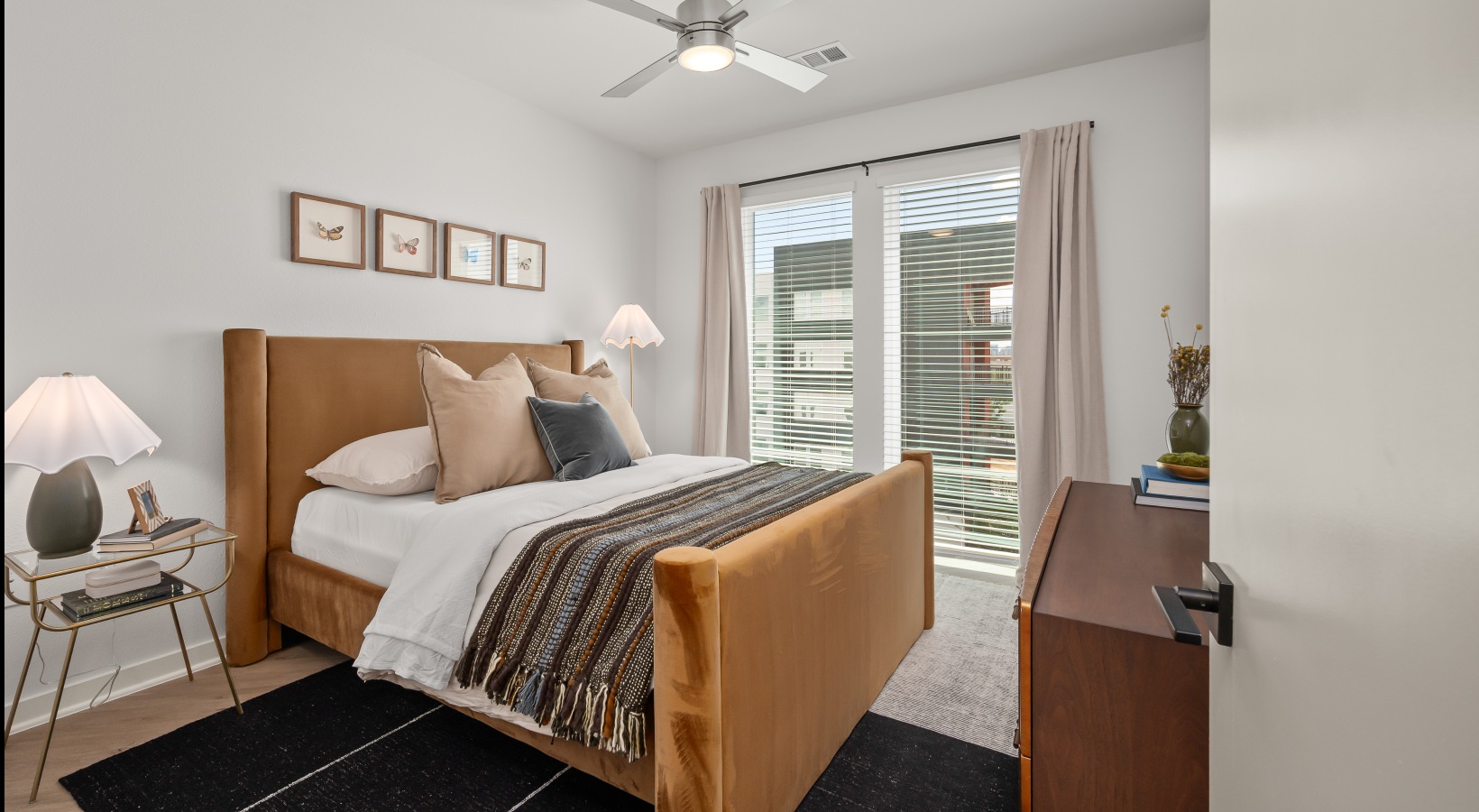 spacious bedroom in the 2 bedroom model spacious bedroom with wood flooring, ceiling fan, and window with natural lighting