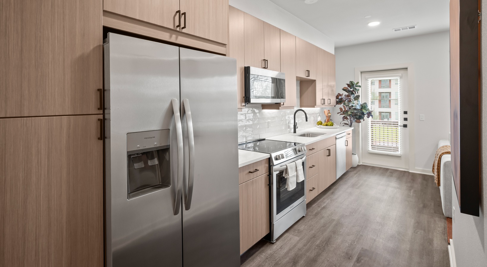 kitchen with wood cabinetry and stainless steel appliances 1 bedroom kitchen with wood flooring and stainless steel appliances