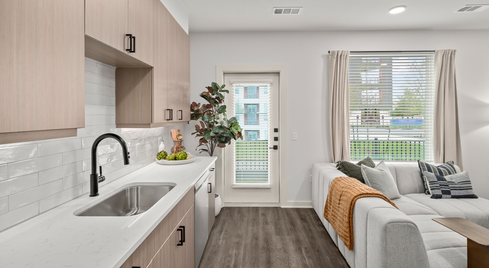 open concept floor plan kitchen with wood flooring overlooking the living room