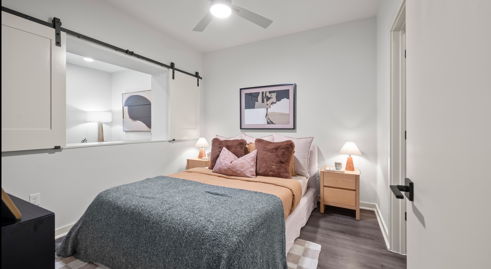 bedroom with private bathroom bedroom with sliding barn window, wood flooring  and private bathroom
