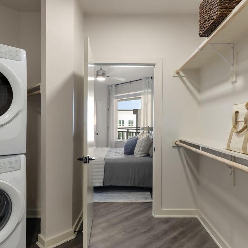 stacked washer/dryer units in bright, spacious closet