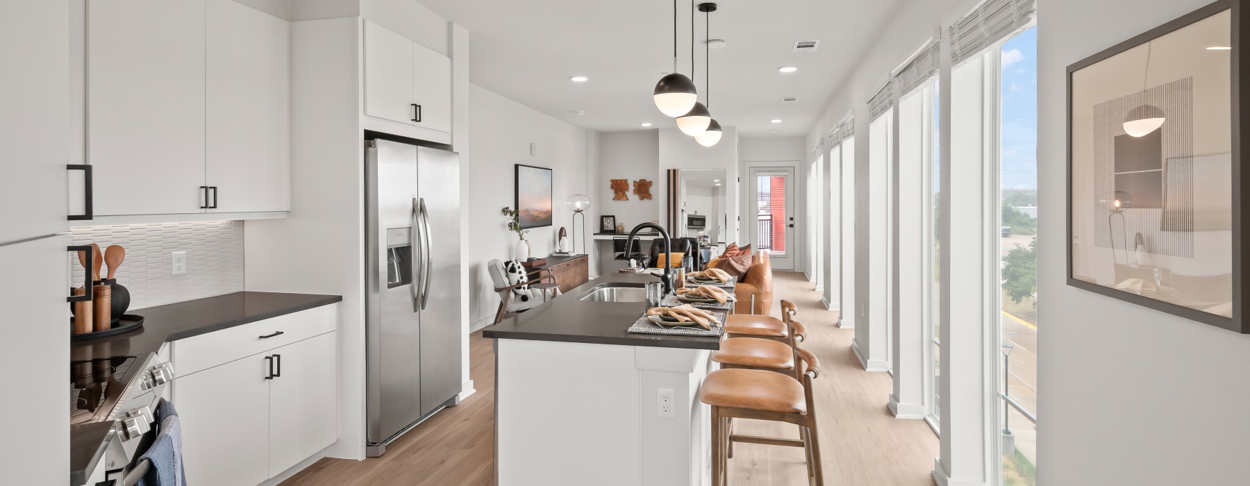 spacious kitchens with thoughtful details a kitchen with a wood floor and white walls
